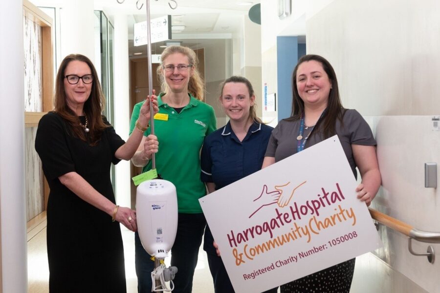Four women are stood in the corridor with the Airglove equipment
